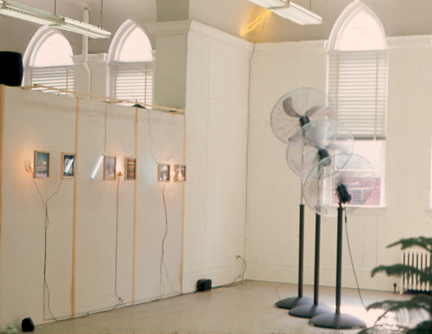 Photograph of two installations by Harry Anderson at VCU's Anderson gallery one employing standing fans and one photographs & neon